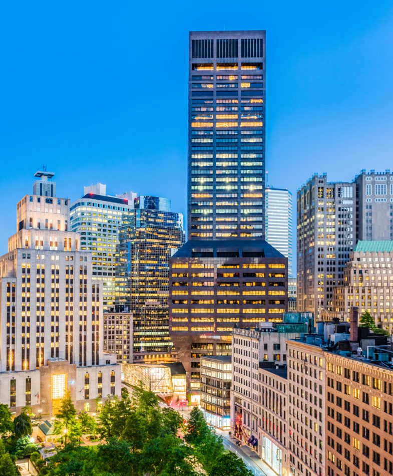 100 Federal Street towering over the city at dusk