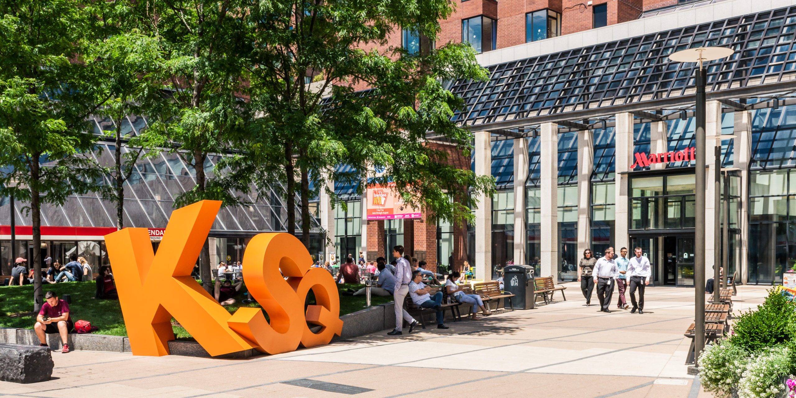 A bustling Kendall Square on a sunny afternoon.